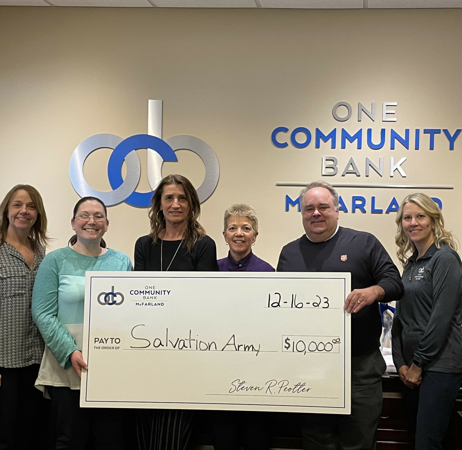 OCB colleagues present a big check of $10,000 to the Salvation Army of Dane County. Steve Heck, with the Salvation Army of Dane County, is pictured to accept the check.