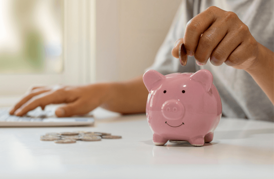 Person adding coins to piggy bank