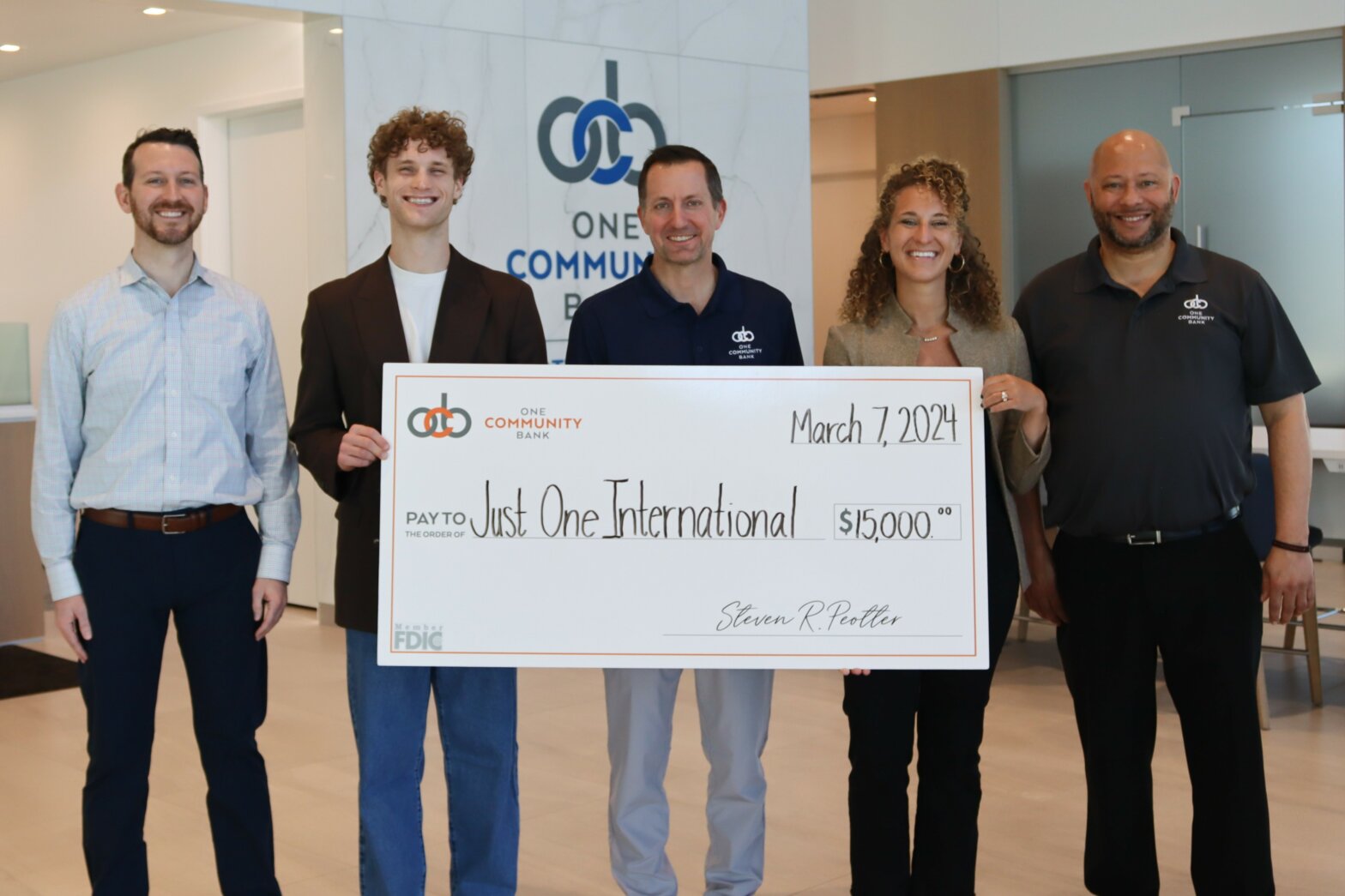 OCB colleagues present check to Just One International