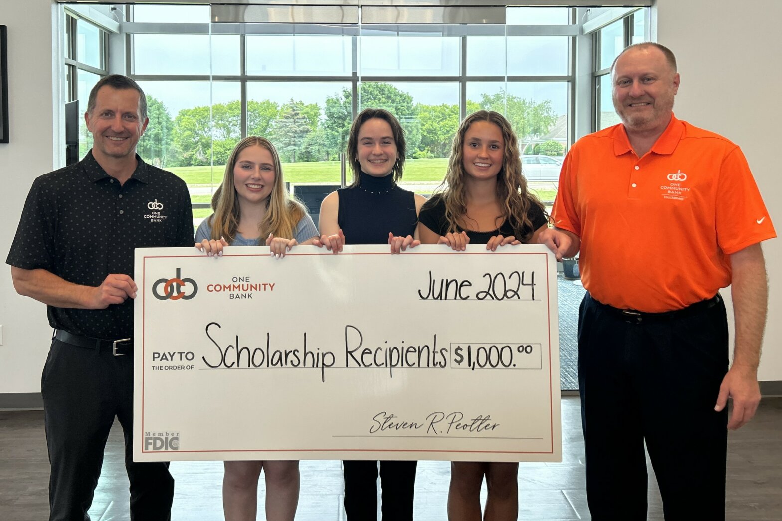 Steve Peotter and Jeff Versluys present a big check to the three 2024 OCB Scholarship Program recipients