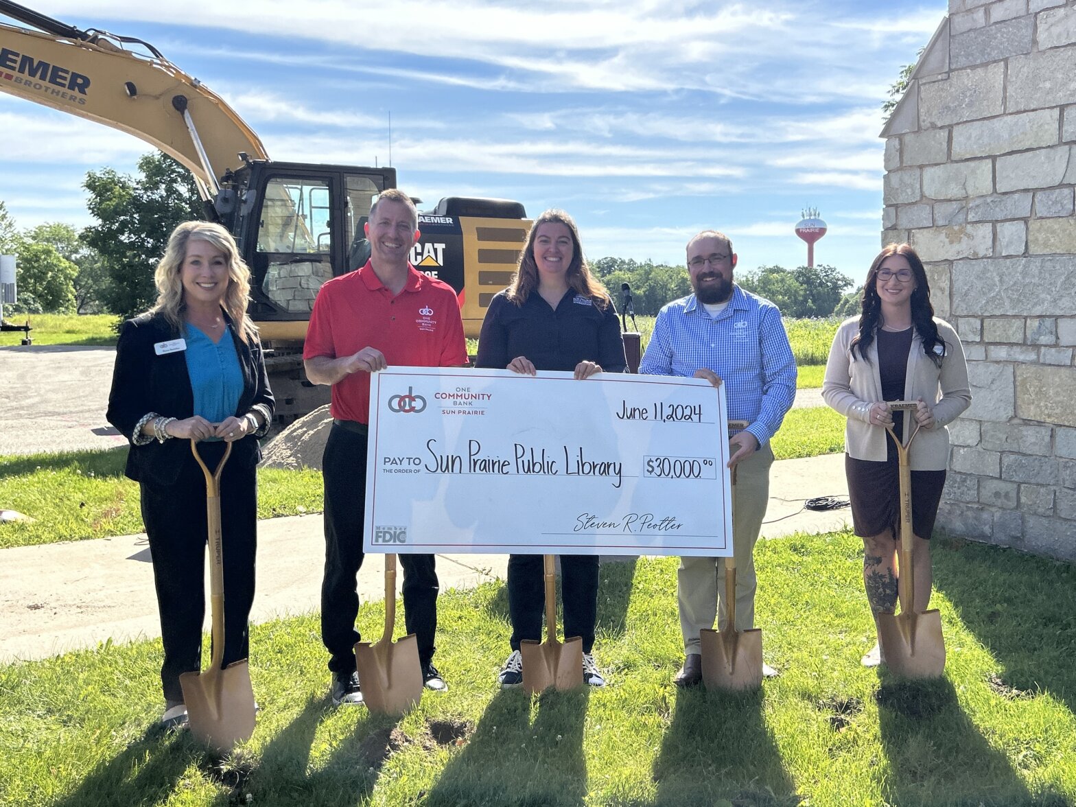 A group of OCB colleagues present a check to Sun Prairie Public Library during their groundbreaking event