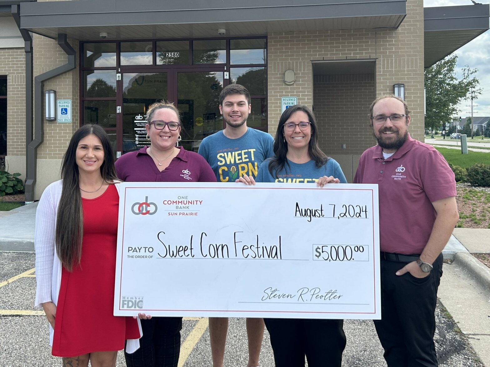 OCB colleagues present a big check to the Sun Prairie Chamber of Commerce for its sponsorship with the upcoming Sweet Corn Festival