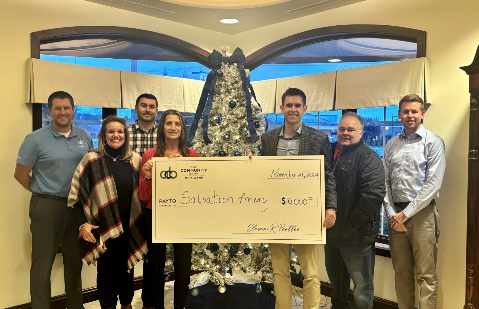 group of people standing with a big check to Salvation Army
