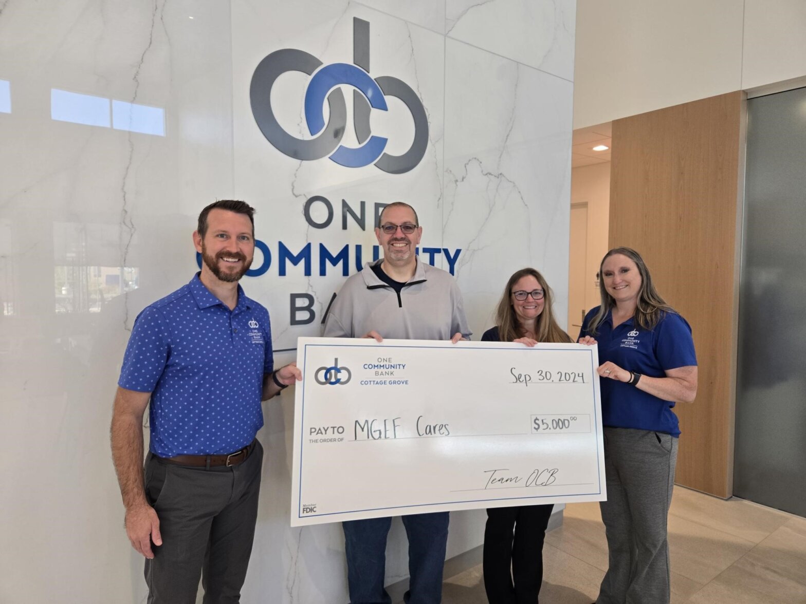 OCB colleagues and guests holding big check for MGEF