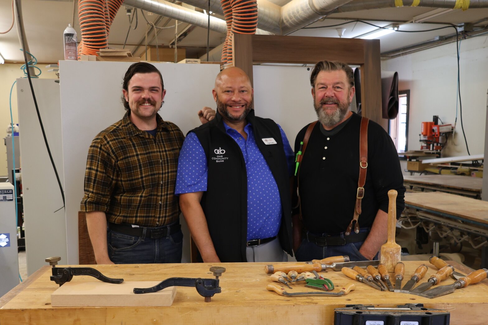 Benjamin Morrow, Reggie Franklin, and David Morrow pose for photo in Misty River Woodworks workshop.